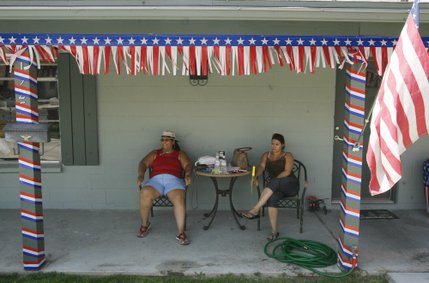 Suzanne Corey, left, and her daughter, Kasey, right, sit in the shade outside a friend's house after attending the 60th annual Damboree parade in Boulder City.