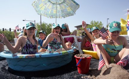 Members of Girl Scout Troop 574 wade in the water and play in sand on a float in the Summerlin Patriotic Parade on July 4.