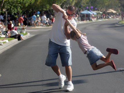While waiting for the Summerlin Patriotic Parade to begin, Tom Johnson spins his daughter, Savannah, in the Streets on July 4.  