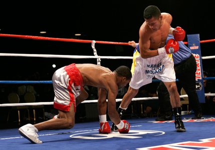WBO junior welterweight champion Ricardo Torres, right, stands over Kendall Holt after knocking him down for the second time in the first round of their title fight at Planet Hollywood.