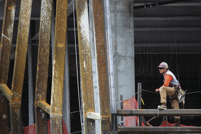 An ironworker looks out from the Cosmopolitan this week. Deutsche Bank, the project's primary lender, took possession of the property after its developer, New York condo builder Ian Bruce Eichner, defaulted on a $760 million construction loan.