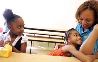 Nilah Pierce, from left, watches as Avianna Chappel hugs project director LaShelle Whitmore during the Rainbow Dreams Academy charter school's summer enrichment program in Las Vegas Monday, July 20, 2009. 