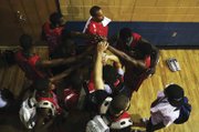 The RAIDERS of Philadelphia huddle after winning a game Wednesday. The Great Falls pair look for big and/or athletic players. But "for every one that works out, you fail with a hundred others," Riley says.
