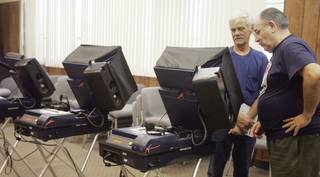With the help of volunteer, Manny Escobedo, right, Russell Murray, left, takes advantage of early voting for the primary election at City Hall in Boulder City on Aug. 5.