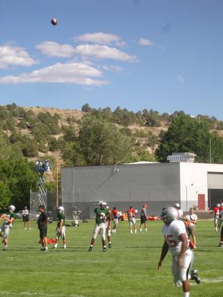 Jason Davis, in white, runs down a fade pass from Omar Clayton Sunday afternoon during UNLV football practice in Ely. The Rebels are up in the mountains until Aug. 19.