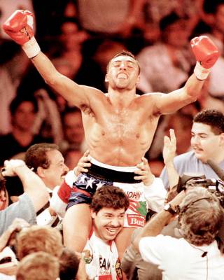 Oscar De La Hoya celebrates his win over Julio Cesar Chavez on the shoulders of his trainer at Caesars Palace in 1996.