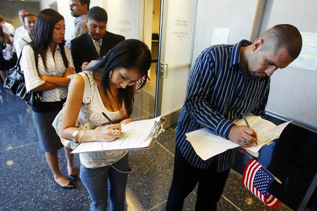 New U.S. citizens Jenette Chavez, 18, left, and Josue Cano, 20, fill out forms as they register to vote at the George Federal Building in Las Vegas on Aug. 22, 2008. 