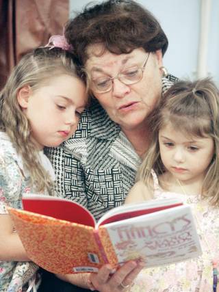 School board representative Sheila Moulton reads to her granddaughters, Jessica, left, and Abigail Farnsworth, right, during an open house at Edna F. Hinman Elementary School on Friday. Over the summer, the school was refreshed with a complete interior makeover.