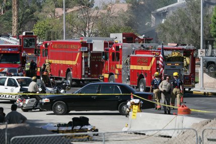 Firefighters spray fire retardant on a house after a twin-engine Piper Navajo crashed into a home on North Jones Boulevard near Cheyenne Avenue today.