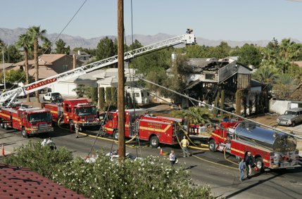 Firefighters investigate a house fire on North Jones Boulevard near Cheyenne Avenue after a twin-engine Piper Navajo crashed into the home Thursday, Aug. 28, 2008.  