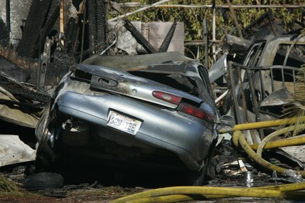 A Mercury is among the rubble after a twin-engine Piper Navajo crashed into a home on North Jones Boulevard near Cheyenne Avenue Thursday, Aug. 28, 2008.  