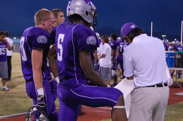 Senior Alex Jones listens to a play with other teammates ...