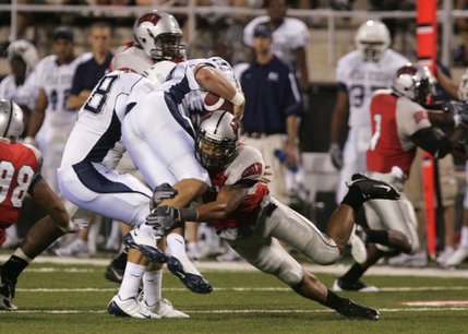 UNLV linebacker Starr Fuimaono takes down Utah State quarterback Sean Setzer during the first half at Sam Boyd Stadium.