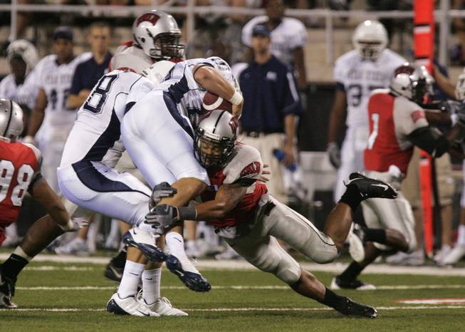 UNLV linebacker Starr Fuimaono takes down Utah State quarterback Sean Setzer during the first half at Sam Boyd Stadium in last season's opener.