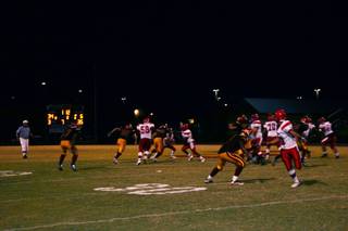 Players spring into action as the ball comes into play during Friday night's football game at Del Sol. 