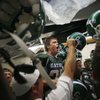 Green Valley wide receiver Kyle Larimer, center, hypes up his team in the locker room before a home 