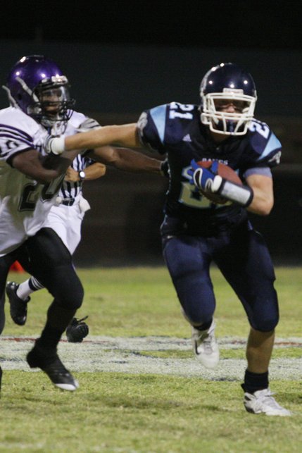 Centennial wide receiver Matt Holley (21) keeps Durango running back Romell Maxwell away during the season opener at Centennial High School on Aug. 29.
