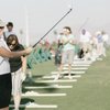 Kaye Polivka gestures as she practices her drive during Women's Play Golf America Day.