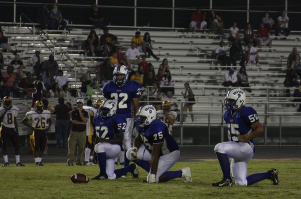 Members of the Basic High School football team wait Friday ...