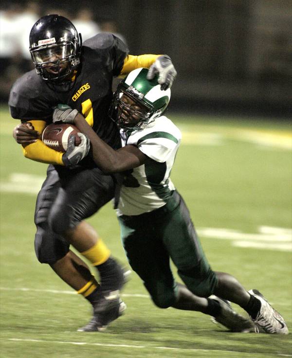 Andre Clay, left, of Clark High School is tackled by ...