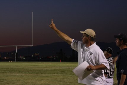 A member of the Coronado coaching staff calls a play from the sidelines Friday as the Cougars take on the Shadow Ridge Mustangs.