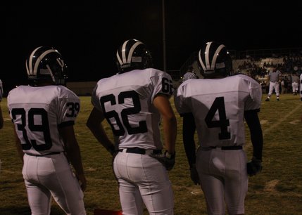 Three Shadow Ridge players watch the on-field action from the sidelines during the team's Friday night matchup against Coronado.