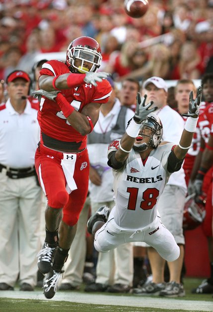 As Utah head coach Kyle Whittingham watches (far left), this pass intended for UNLV wide receiver Phillip Payne falls just out of his reach.