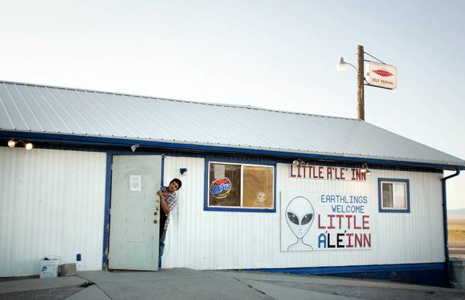 Cody Theising, 19, pokes his head out of the A'Le'Inn to talk to people outside. Theising's mother, Connie West, owns the bar in a double-wide trailer, which also serves as a diner, motel and social center.
