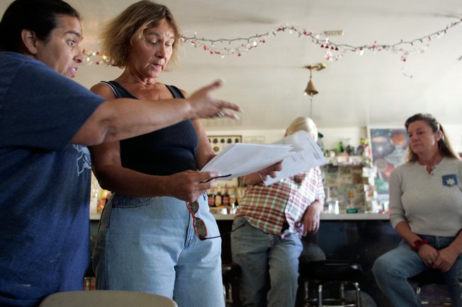 Connie West, left, owner of the A'Le'Inn, and Rachel resident Chris Bickel look over documents on the proposed private prison. Many oppose the plan, fearing it will bring danger and disruption of their lifestyle.