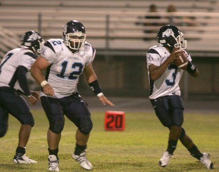Centennial quarterback Chris Henderson, right, looks for a pass during an away game against Green Valley on Friday night. 