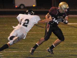 Crusaders wide receiver Don Pearson protects the ball from Spring Creek tackler Marty Shanks during a game at Faith Lutheran High School on Friday night.