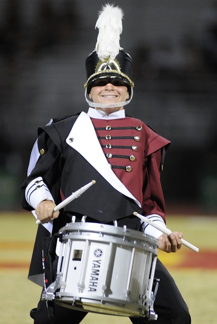 Del Sol freshman Falcon Horowitz smiles for the crowd while keeping the beat with the school marching band during a halftime performance at Del Sol High School on Friday.