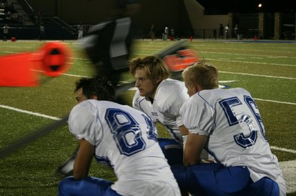 Dixie's Dalton Smith (84), Max Sherwin (56) and Mike Sharp (1) pause to discuss some plays at the end of the first quarter. The Flyers scored their first touchdown at the end of the first, bringing the score to 14-6.