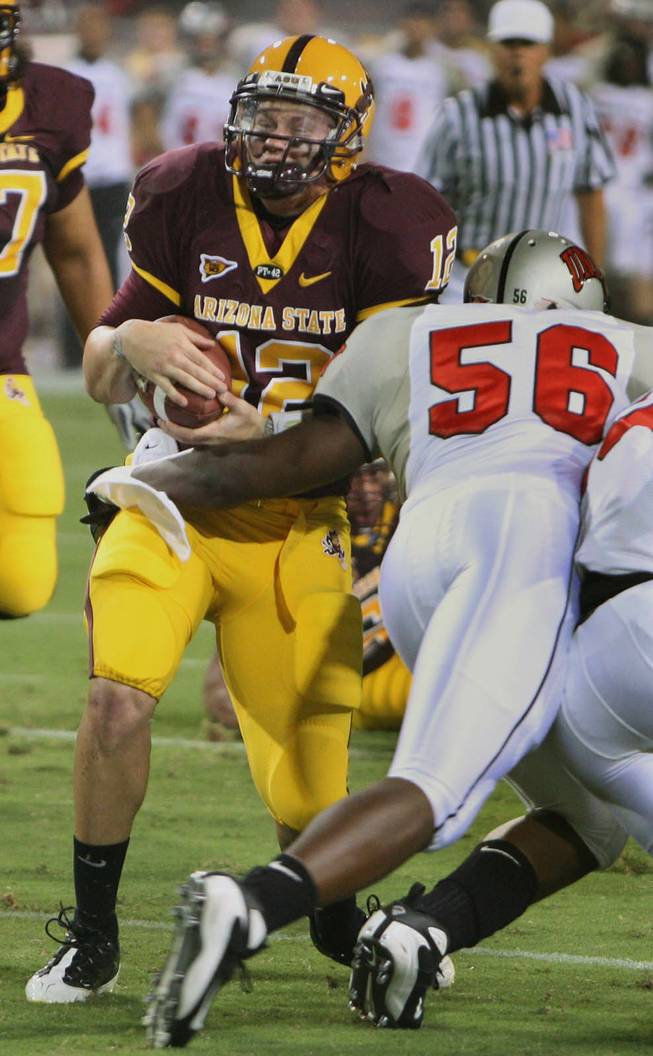 UNLV linebacker Ronnie Paulo (56) tackles Arizona State quarterback Rudy Carpenter, left, in the first quarter of the Rebels' 23-20 upset overtime victory over the then-No. 15 Rebels in Tempe on Sept. 13, 2008.
