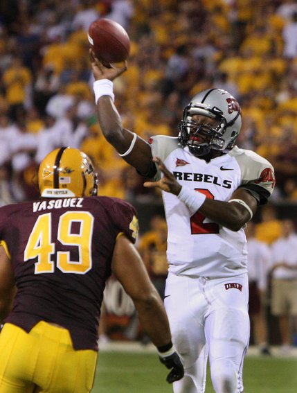 UNLV quarterback Omar Clayton, right, throws a touchdown pass over Arizona State defensive end Luis Vasquez (49) during the second quarter.