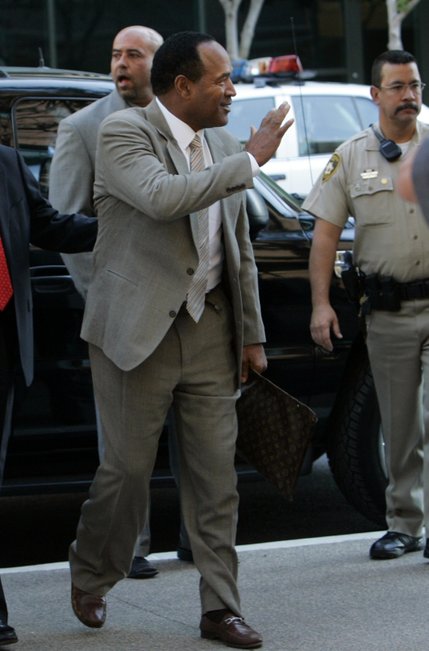 O.J. Simpson waves to media and onlookers as he arrives for the first day of his trial at the Clark County Regional Justice Center in Las Vegas, Nev., Monday, Sept. 15, 2008. Simpson is facing charges that include burglary, robbery and assault following an alleged robbery at the Palace Station Hotel & Casino in September, 2007. 