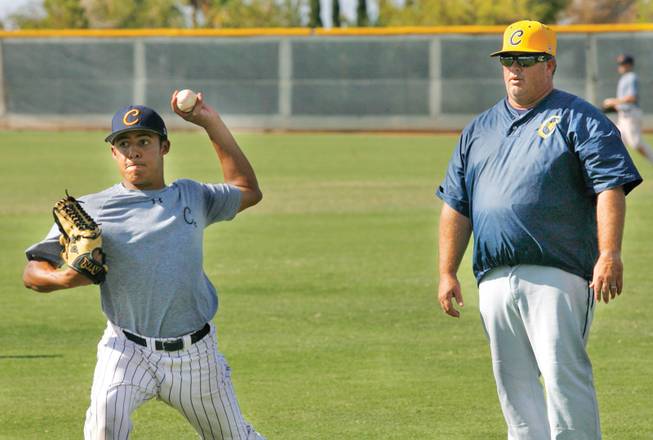 CSN's baseball pitching coach Glen Evans looks on as freshman Brandon Evans throws a pitch during practice.