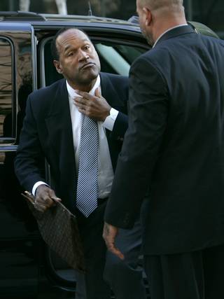 O.J. Simpson adjusts his tie as he arrives at the Clark County Regional Justice Center in Las Vegas, Nev., Wednesday, Sept. 17, 2008. Simpson faces charges that  include burglary, robbery and assault following an alleged robbery at the Palace Station Hotel & Casino in Sept., 2007. 