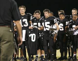 Chaisson Prescott (13) and Tyler Leet (15) hold the jersey of Christopher Privett, a Palo Verde freshman who was shot and killed while walking home in February. The school retired Privett's jersey during a halftime ceremony Thursday.