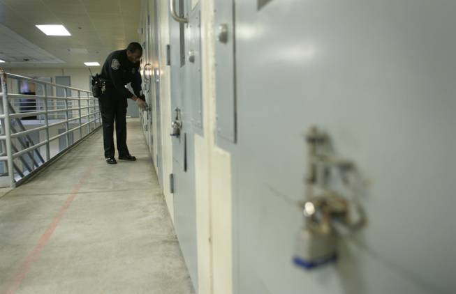 Officer Tyrone Bentley unlocks food flaps in cell doors of the North Las Vegas Detention Center, which houses dangerous federal detainees.