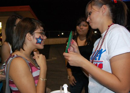 A Valley fan gets her face painted by another student on Friday night. 