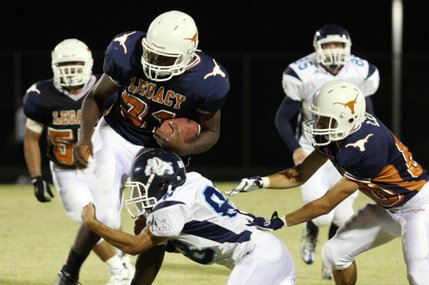 Centennial defensive back Nick Waters, center, attempts to take down Legacy's Prince Oroke during Friday's homecoming game at Legacy High School.