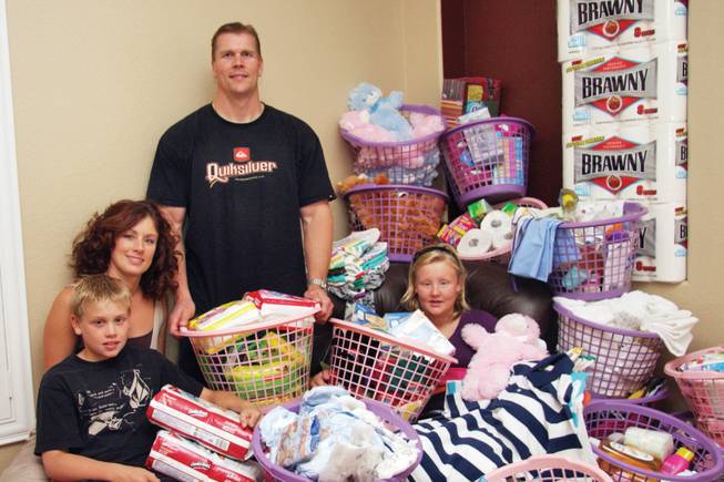 Mattie Wendel, 13, right, poses with her family -- from left, Nick, 10, Danielle and Myron -- in the middle of donated clothing, toiletries, and other items she collected for Olive Crest Foster Care and the Shade Tree Shelter.