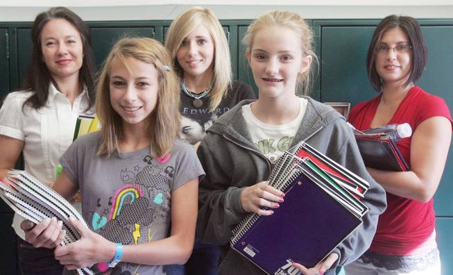 From top left, members of the National Junior Honors Society, Rachael Mikita, adviser, Megan Shannon, Colleen Larreau, adviser; from front left, Brittany Nickels and Sammantha Niemeier, stand with school supplies collected as part of a community service project at Jack Lund Schofield Middle School. 
