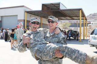 Staff Sgt. Kevin Johnson, right, goofs around with his friend, Specialist James McFarland, during Thursday's welcome home celebration at the Henderson Armory.