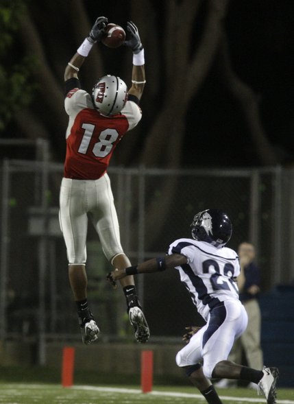 UNLV's Phillip Payne makes a catch over UNR's Joe Easter during the Rebels' game against the Wolf Pack at Sam Boyd Stadium.