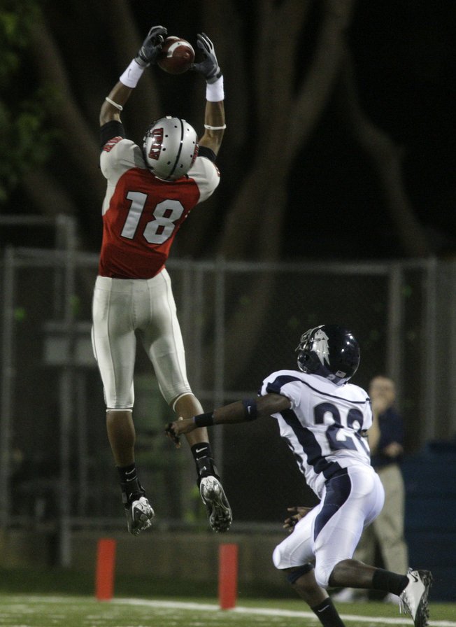 UNLV's Phillip Payne makes a catch over UNR's Joe Easter during the Rebels' game against the Wolf Pack at Sam Boyd Stadium.
