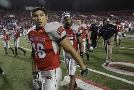UNLV players Tyler Walker, left, and Marquel Martin leave the field Saturday night after UNR defeats the Rebels at Sam Boyd Stadium.
