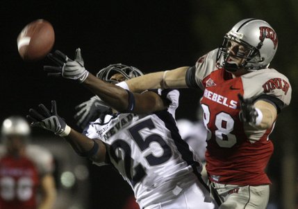 UNR's Mo Harvey, left, breaks up a pass intended for UNLV's Ryan Wolfe during the Rebels' game against the Wolf Pack.