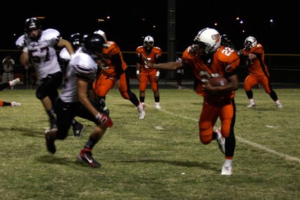 Cowboys running back Isaiah Washington tries to dodge Las Vegas defenders during Friday's game at Chaparral.